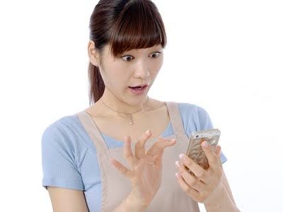 スマホを見てびっくりする女性